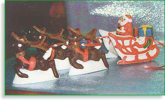 reinderrs pulling santa in sled